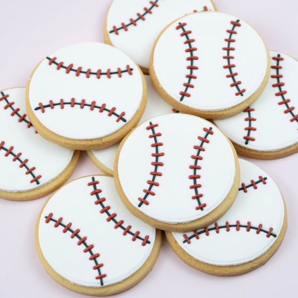 Handcrafted baseball cookies decorated with white fondant and red stitching