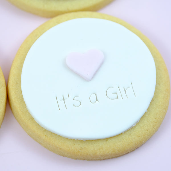 Handmade fondant birth announcement cookies with "It's a Girl" design, baby footprints and personalised birth details