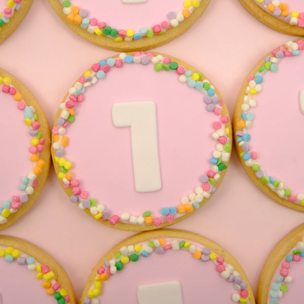 Custom birthday cookies featuring edible photos and pastel fondant numbers