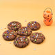 Close-up of chocolate Halloween monster cookie with colourful candy and edible eyes