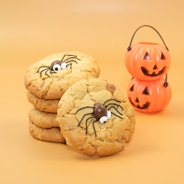 Stack of chunky Halloween cookies decorated with cute edible spiders