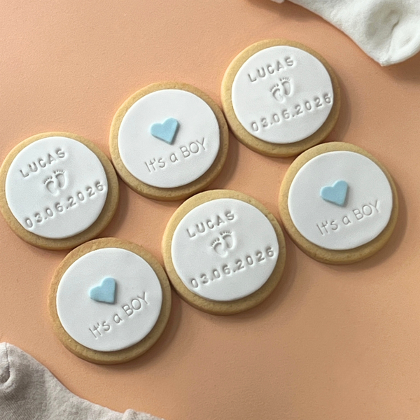 Handmade fondant birth announcement cookies with "It's a Boy" design, baby footprints and personalised birth details